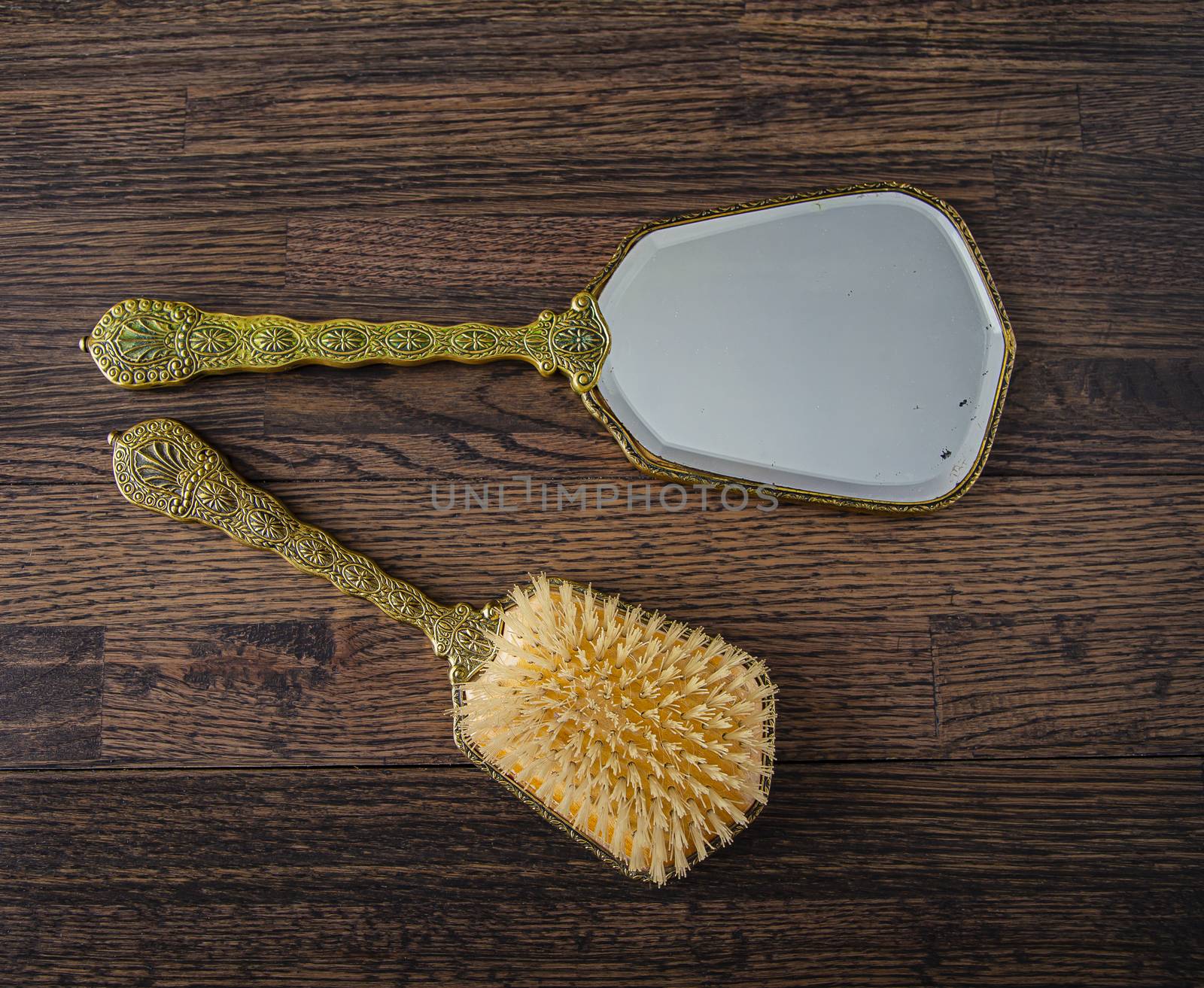 Antique hair brush and hair mirror on a dark oak wood background
