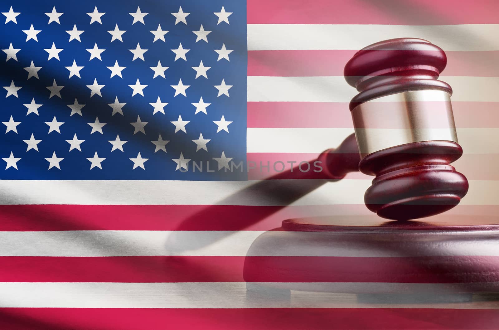 Legal gavel on its plinth over a flag of the USA in a conceptual composite image