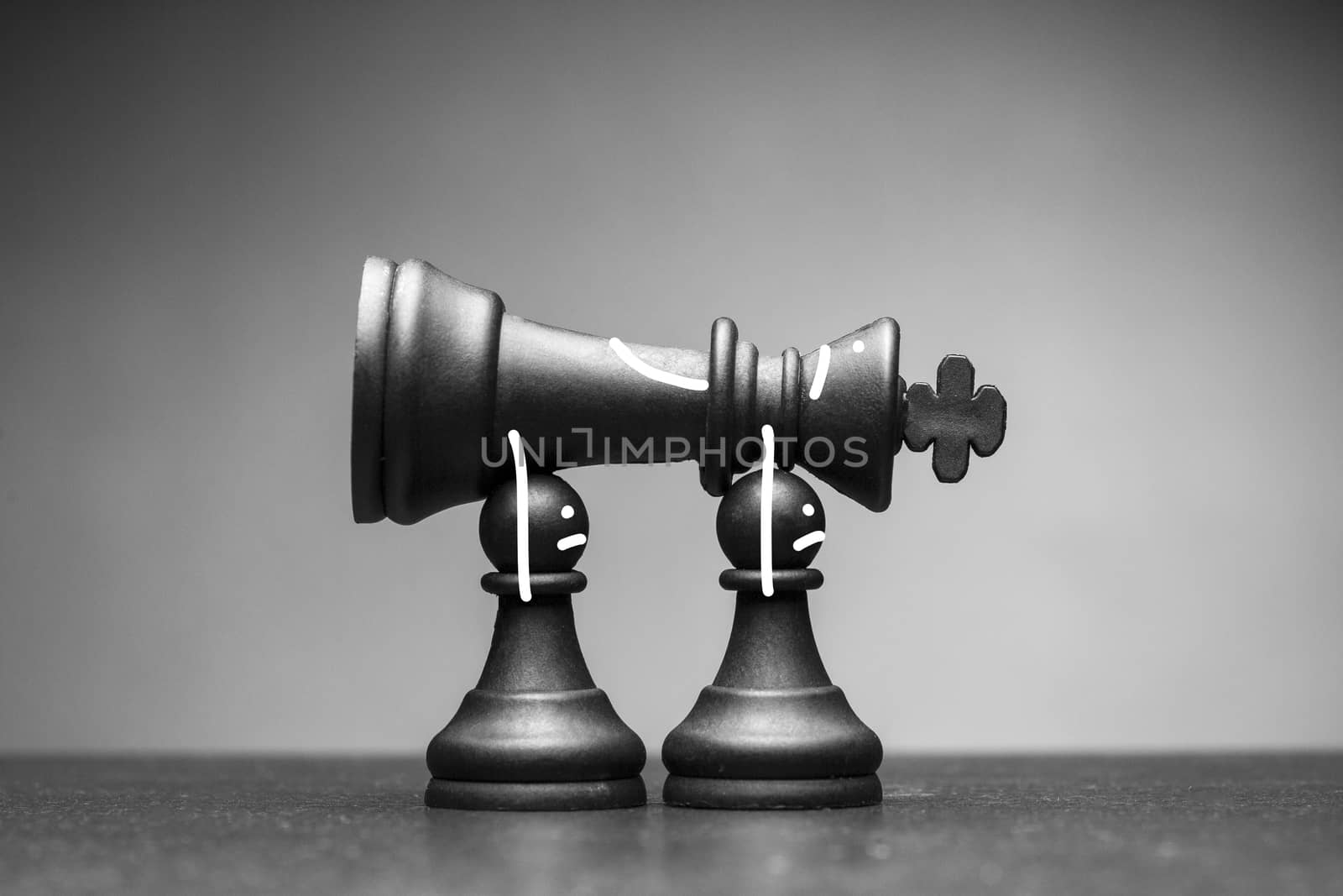 Two black pawn chess pieces carrying away a fallen king raised above their heads in a greyscale conceptual image