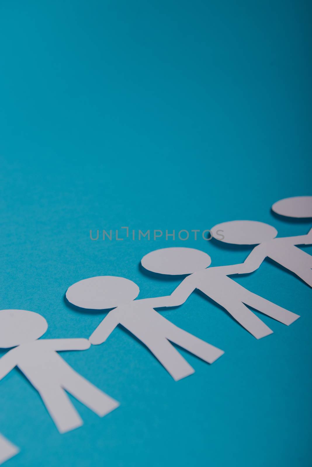 abstract paper people holding for hands on blue background