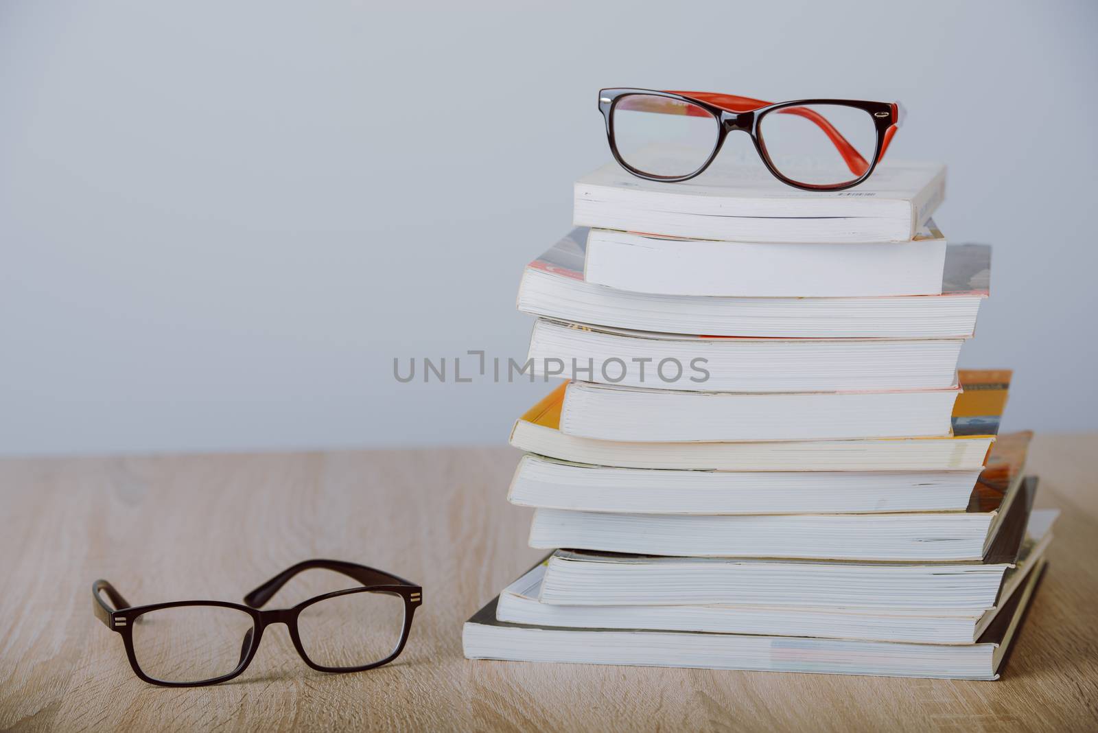 book and eyeglasses on wood background desk