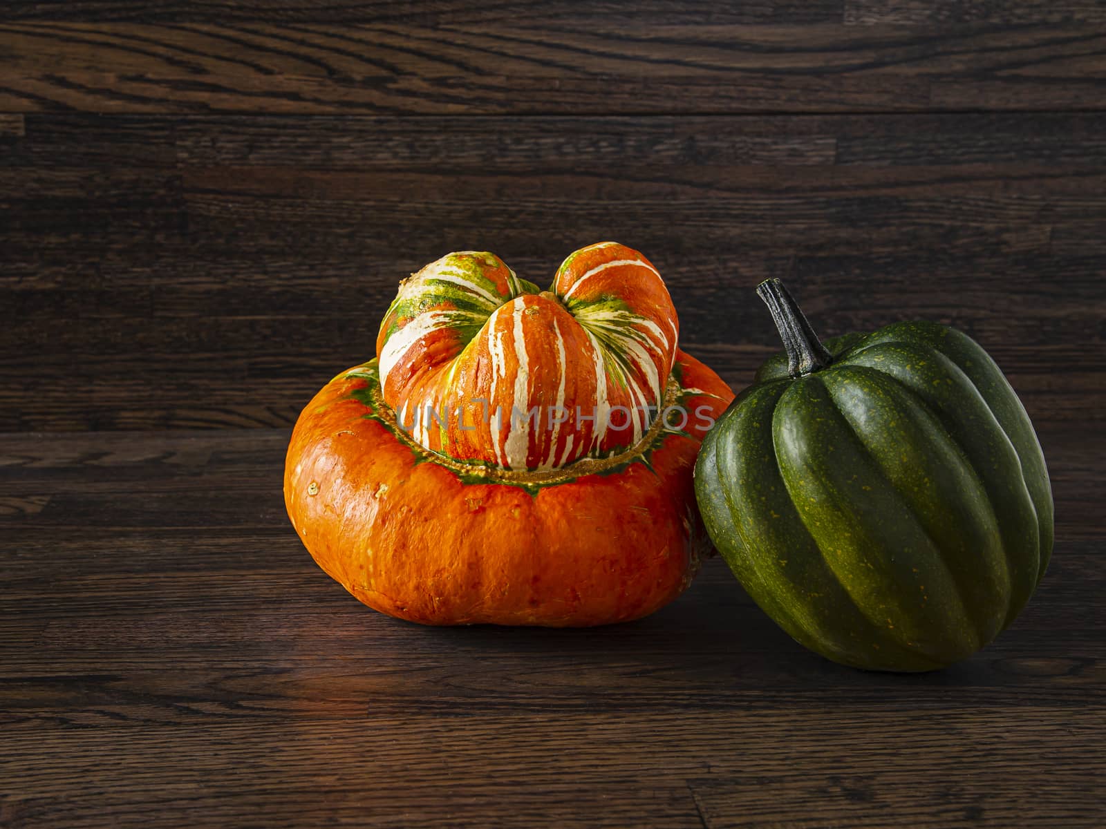 Turban and sweet dumbling squash against a dark wood background