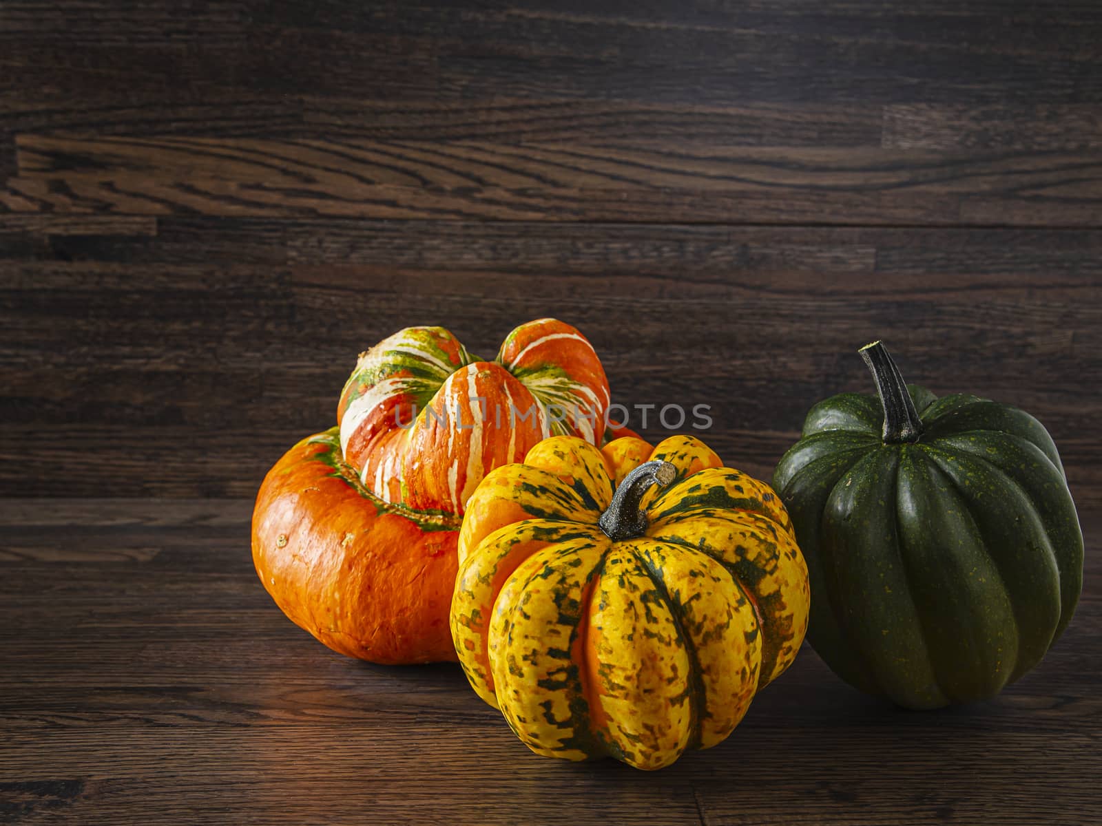 turban squash with yellow and green sweet dumbling squash against a wood background