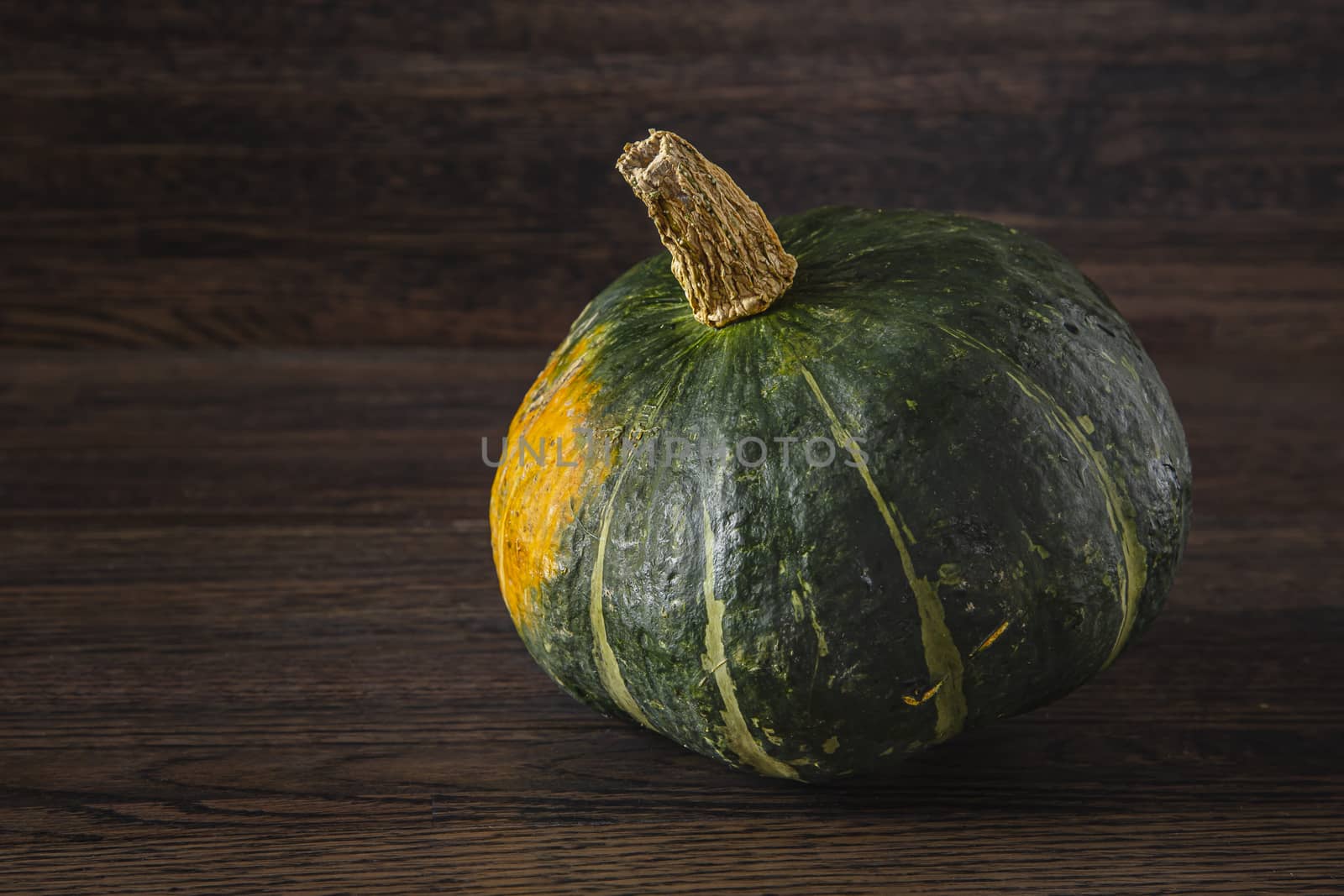 kambocha squash against a dark wood background