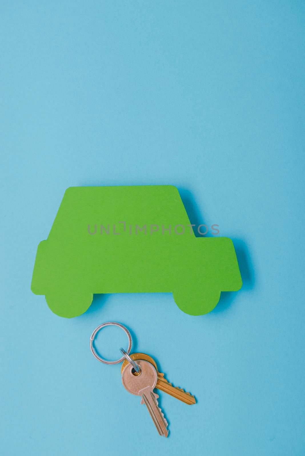 paper green cars figure with keys. top view on blue background