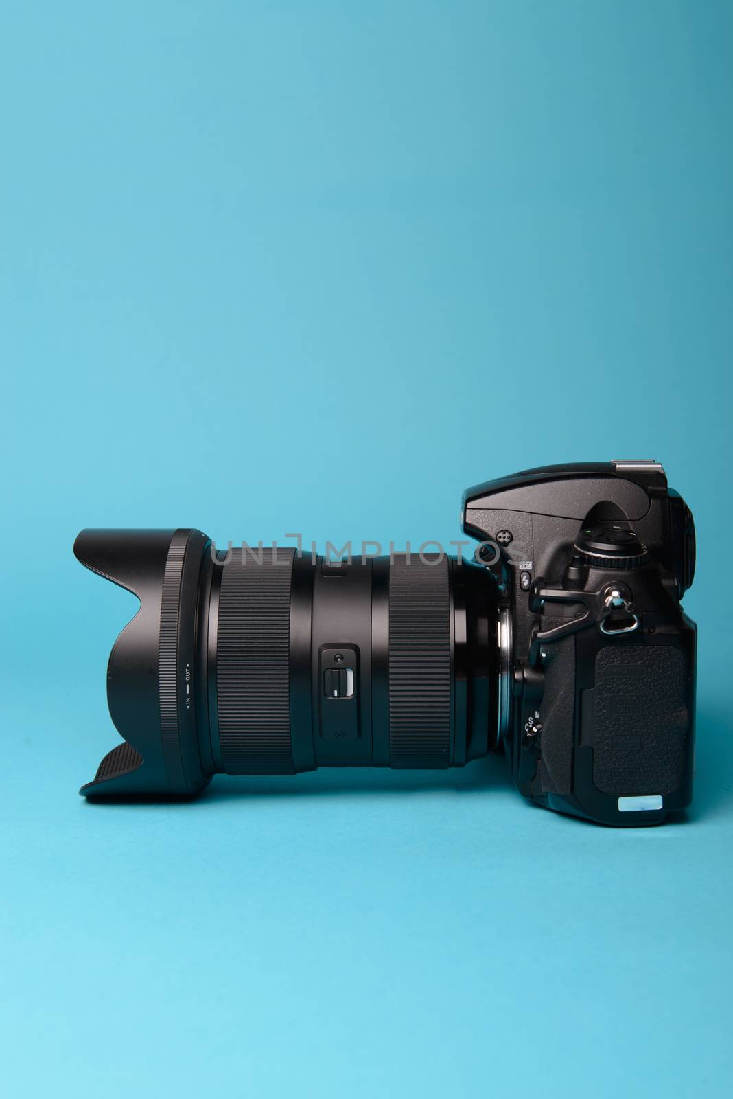 Professional modern DSLR camera against blue background