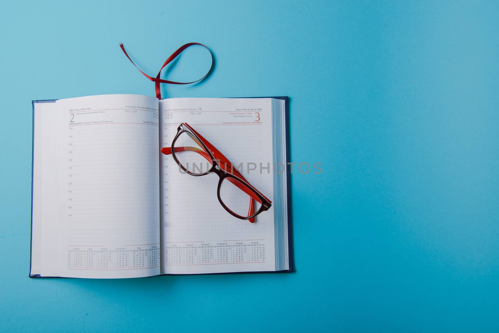 Business planning with copy space and office supplies. Red glasses on blue background