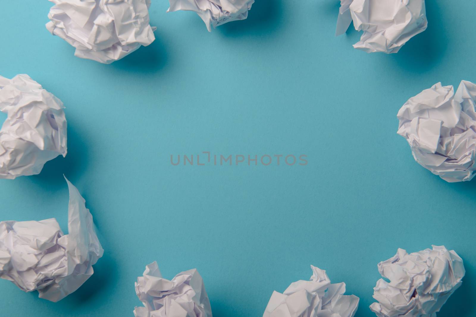 crumpled paper ball isolated on a blue background