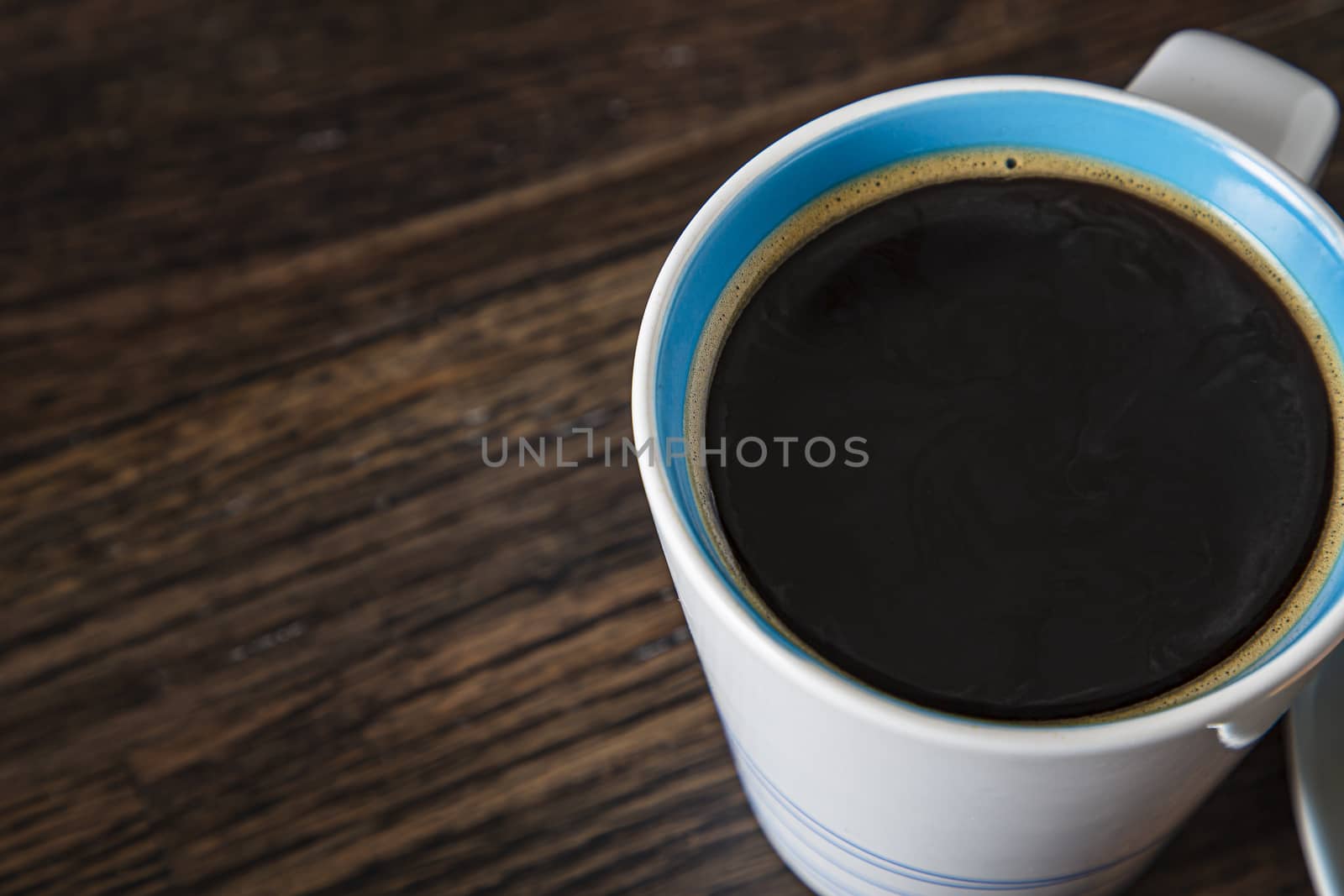 top view of a cup of coffee against a dark brown wood background