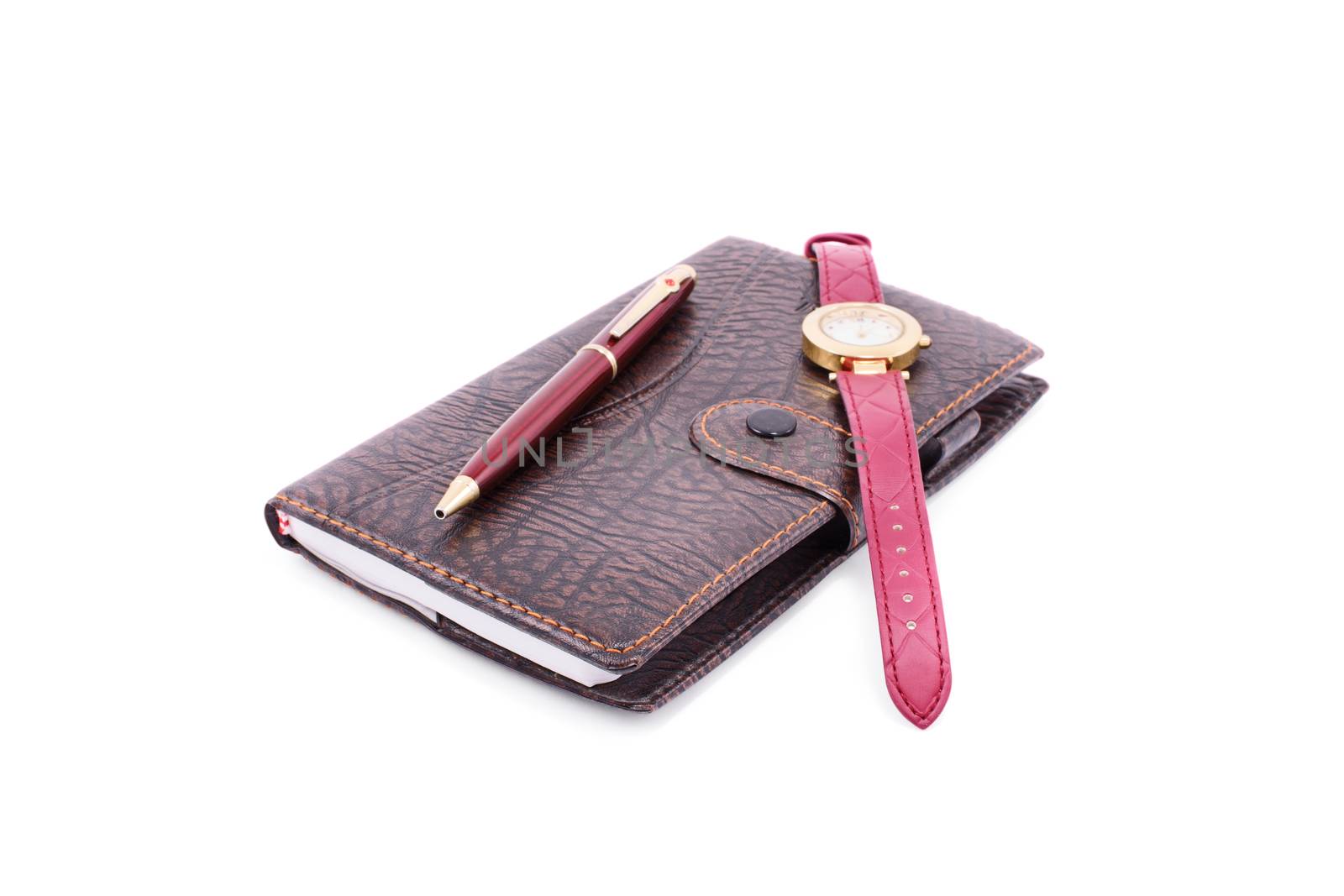 Close up of a planner notebook with a pen and wrist watch, isolated on white background.
