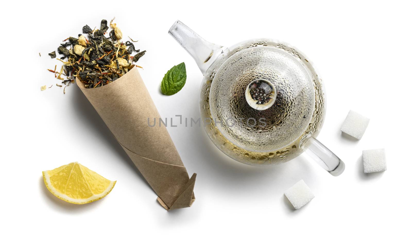 Green tea with natural aromatic additives and a teapot. Top view on white background.