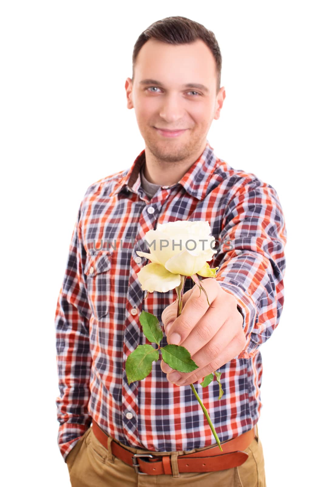 Portrait of a smiling handsome young man handing out a white rose flower to the camera, isolated on white background. Valentine's day, romance, love concept.