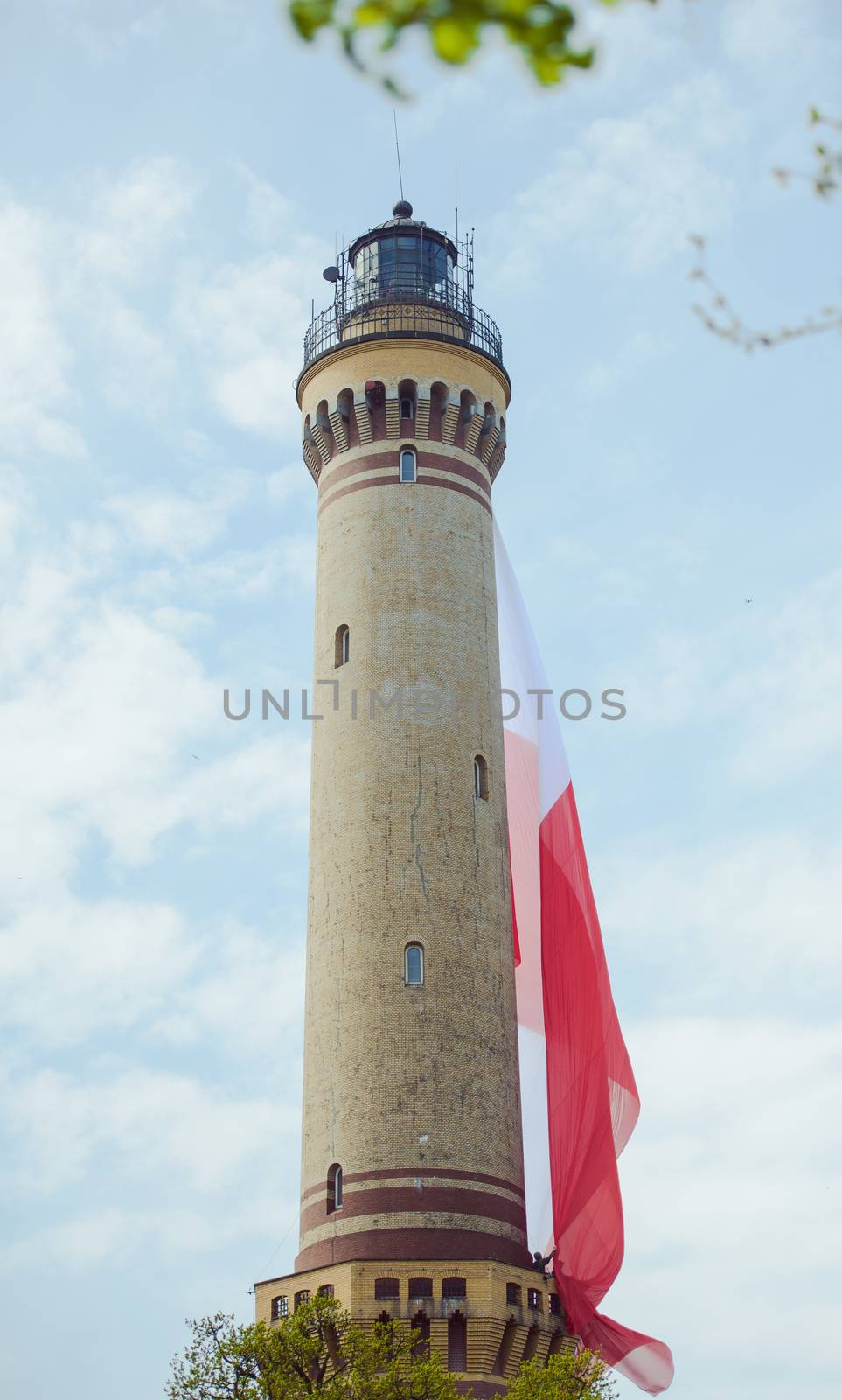 Polish flag hung on at historical lighthouse located in Swinoujscie, Poland, The construction was build in 1828 and height is 65 meters. 19th century. Top tallest Lighthouse in the World