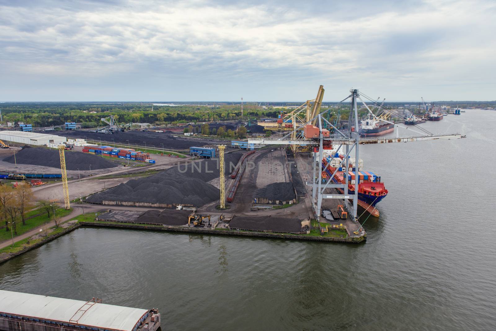 Container ship in export and import business and logistics. Shipping cargo to harbor by crane. Water transport International.