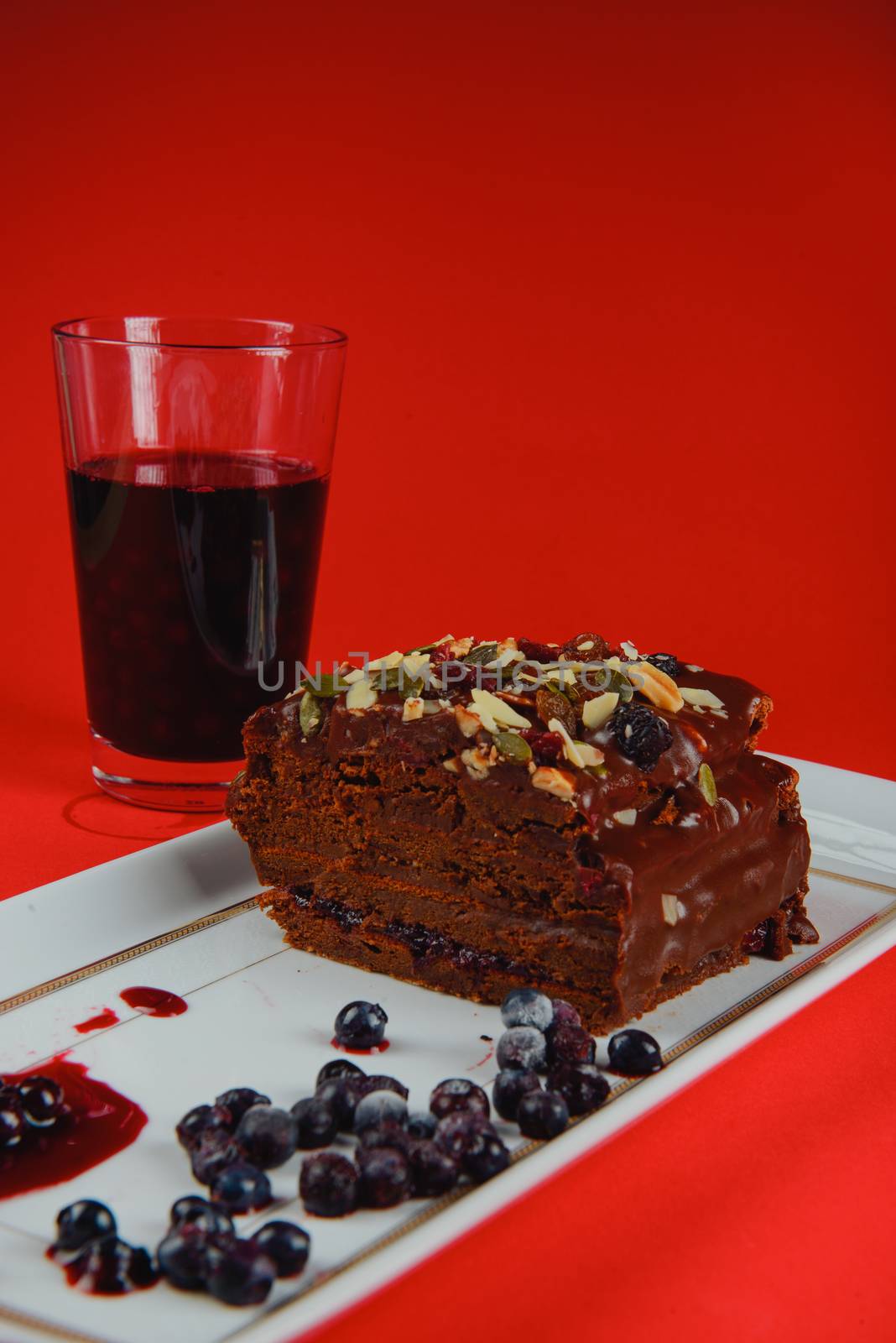 Chocolate cake with raisins lies on the table by Brejeq