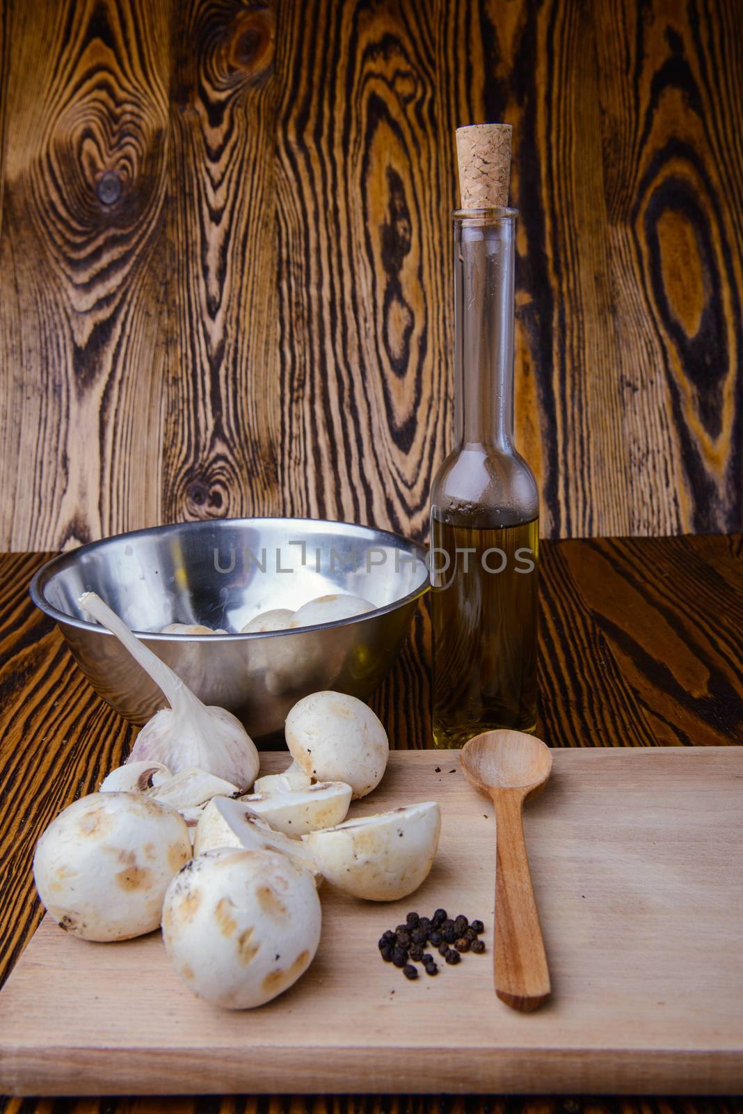composition poured olive oil, mushrooms, garlic on wooden background. healthy food