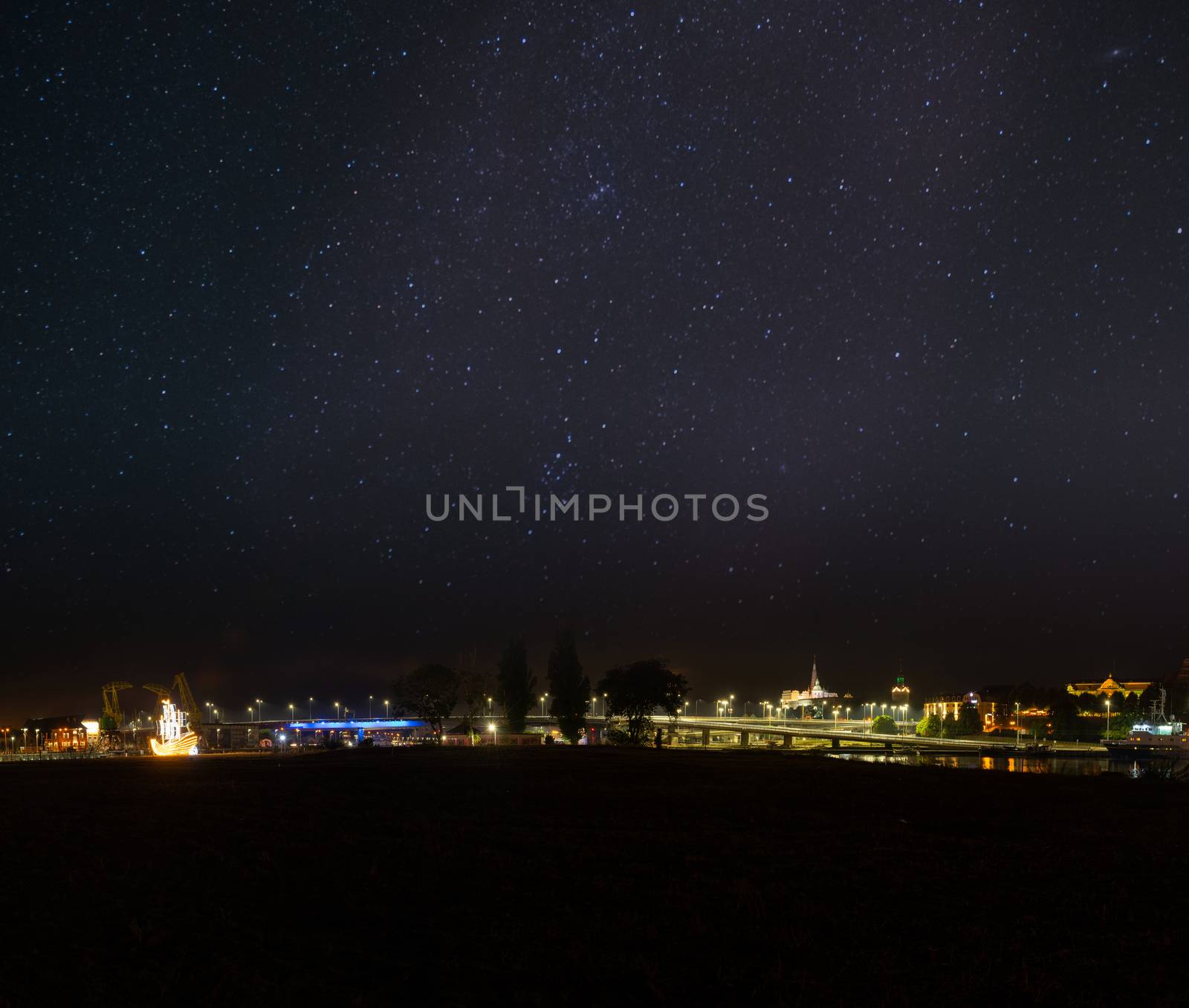 Szczecin. Night view from across the river to the illuminated historic center. Odra river. Chrobry embankments in Szczecin