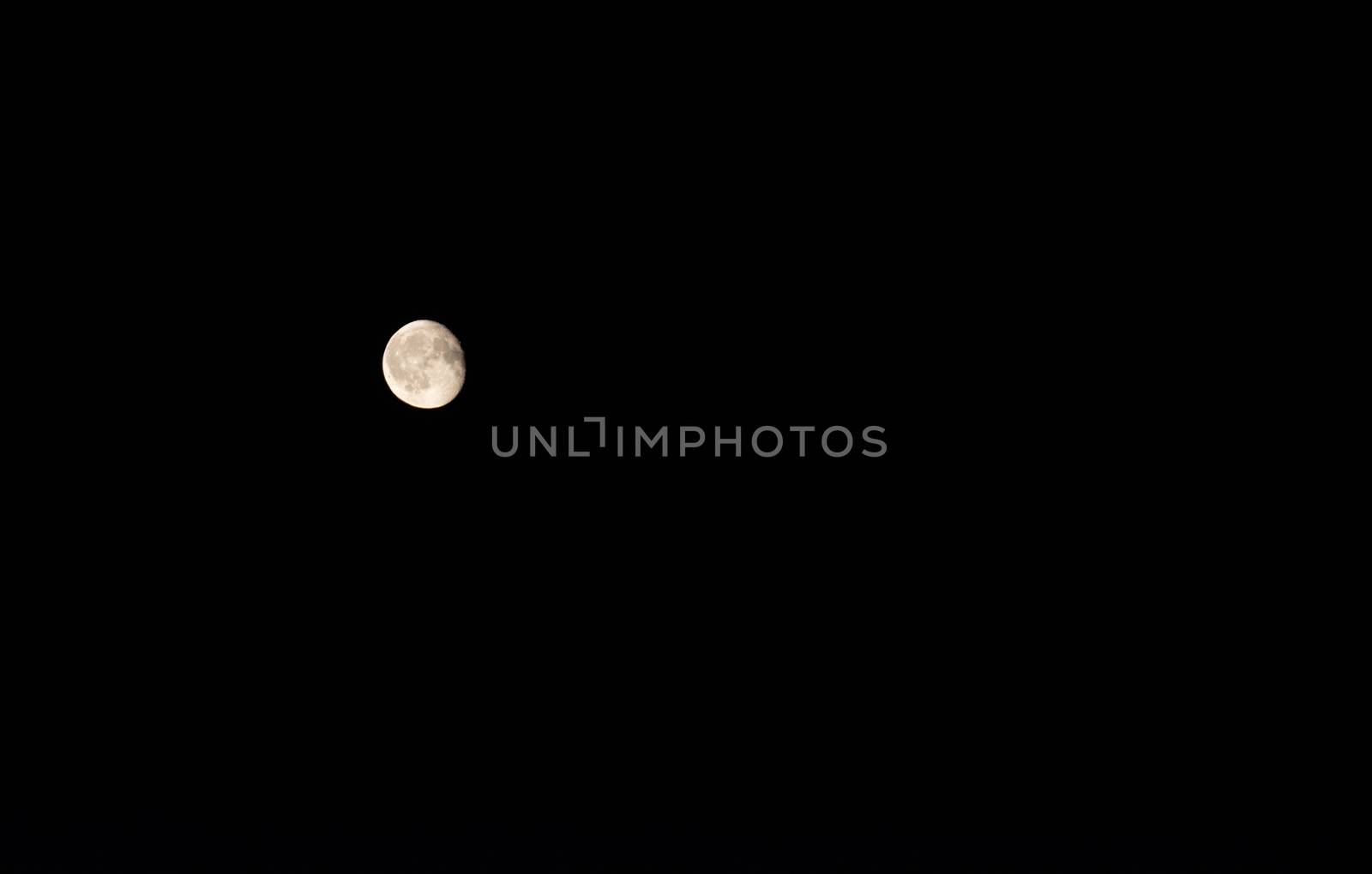 Full moon over dark black sky at night by Brejeq