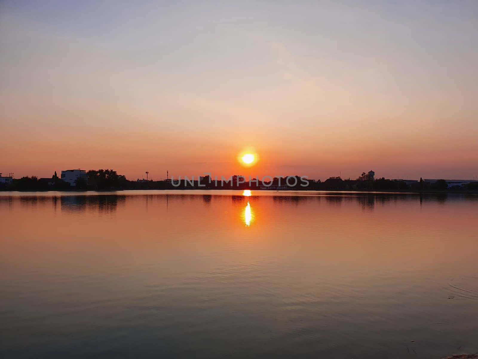 View of sunset over the lake with orange sky in the background