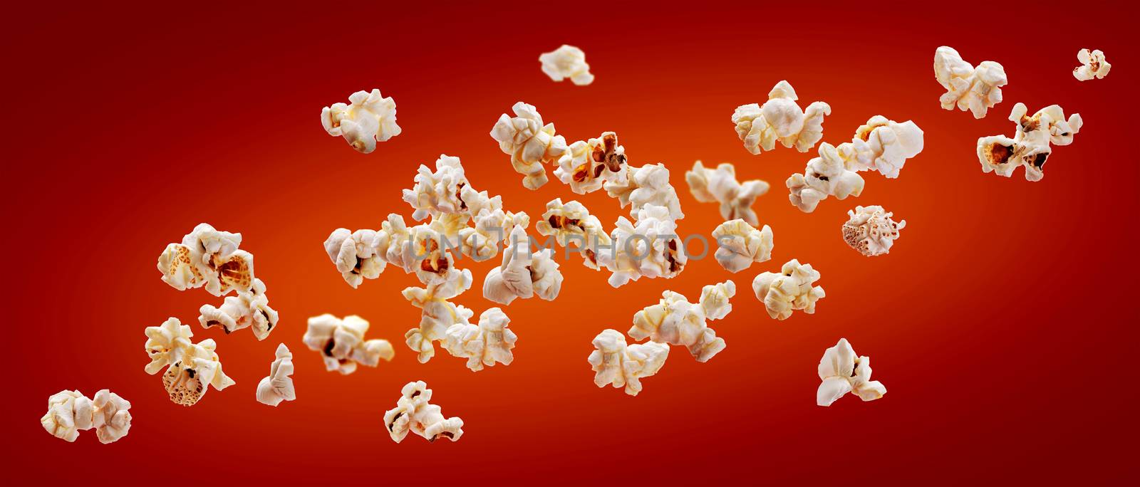 Popcorn isolated on red background. Falling or flying popcorn with copy space. Close-up
