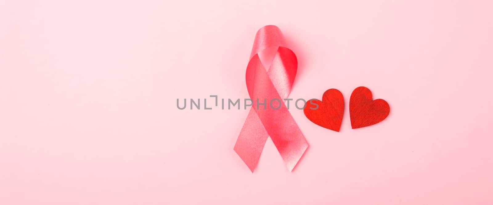 Breast cancer month health concept, flat lay top view, put pink ribbon and Red Heart on pink background with copy space for your text