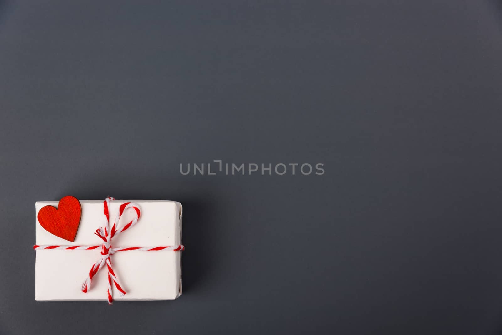 Valentine's day Concept, flat lay top view, White Gift Box and Red Heart on Gray background with copy space for your text