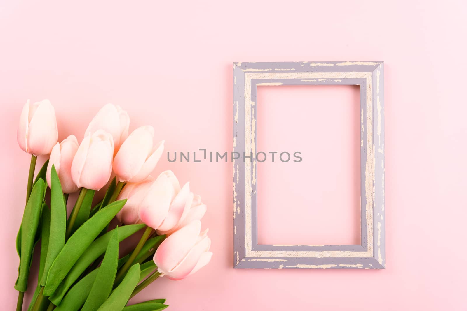 Happy Women's Day, Mother's Day concept. top view flat lay photo frame and Tulip flower on pink background, copy space for your text