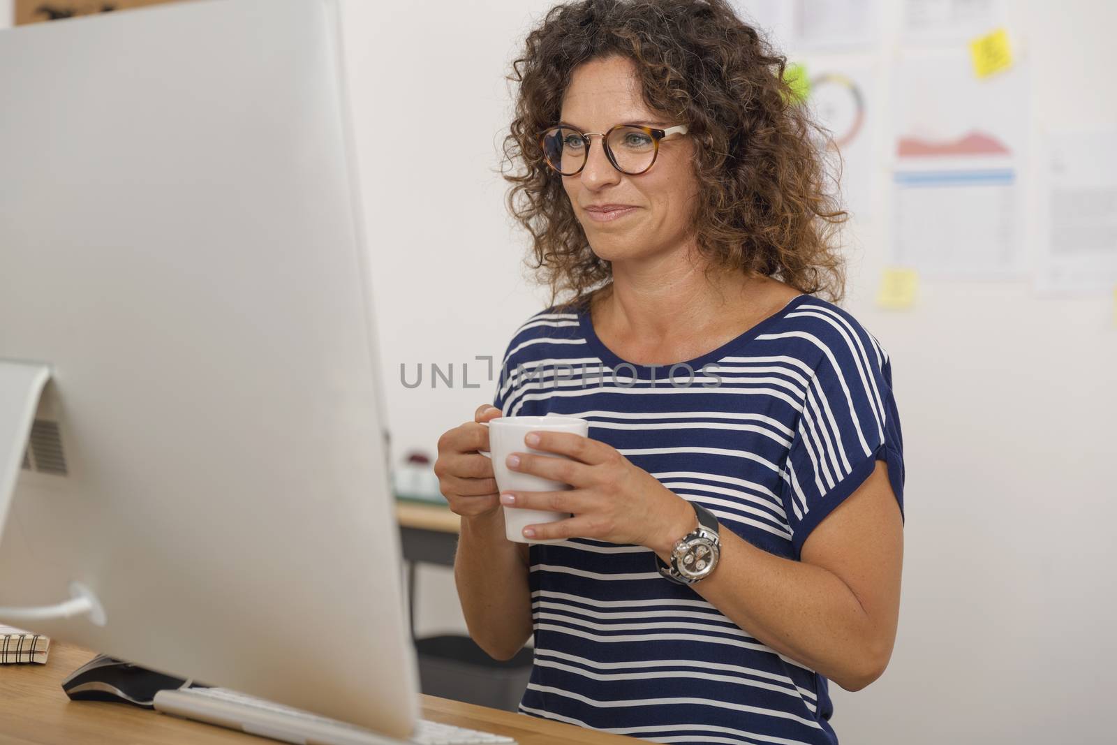 Portrait of a middle aged woman at the office drinking coffee