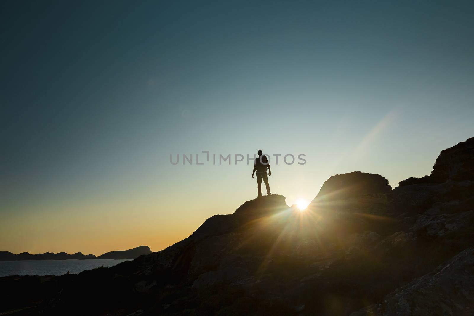 Shot of a man enjoying the view of the montains at sunset