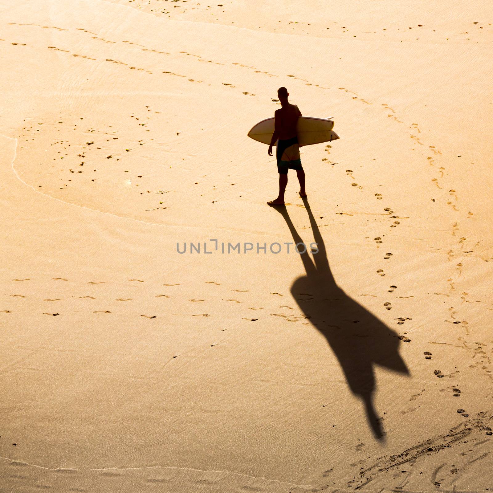 Top view of a surfer on the beach