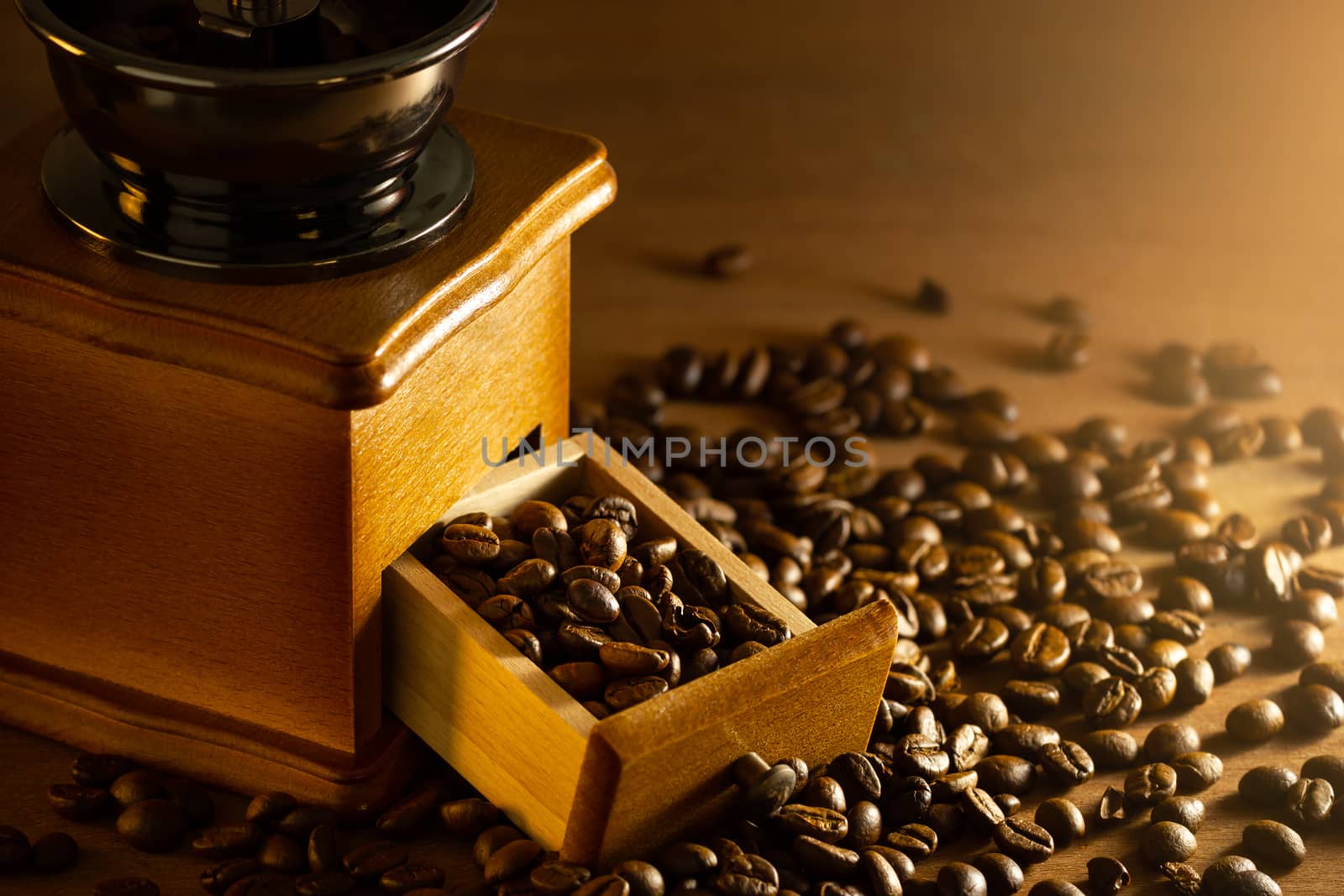 Coffee bean in the tray of grinder on table and morning light. by SaitanSainam