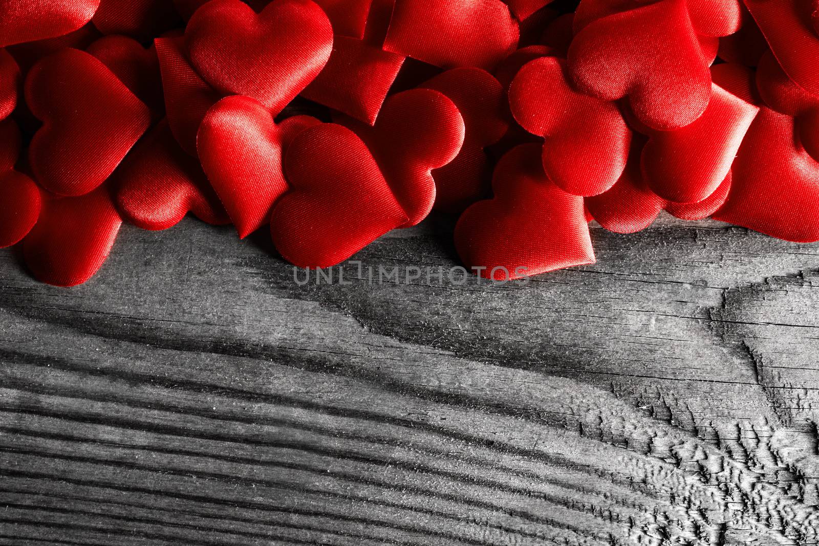 Valentine's day many red silk hearts on wooden background, love concept