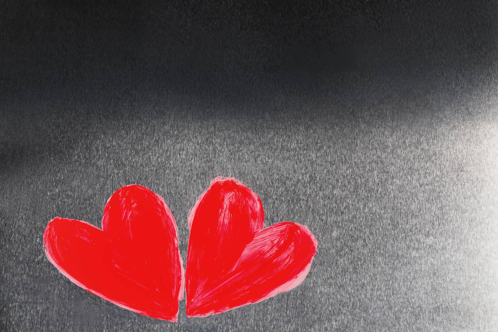Two abstract red painted hearts on metal background