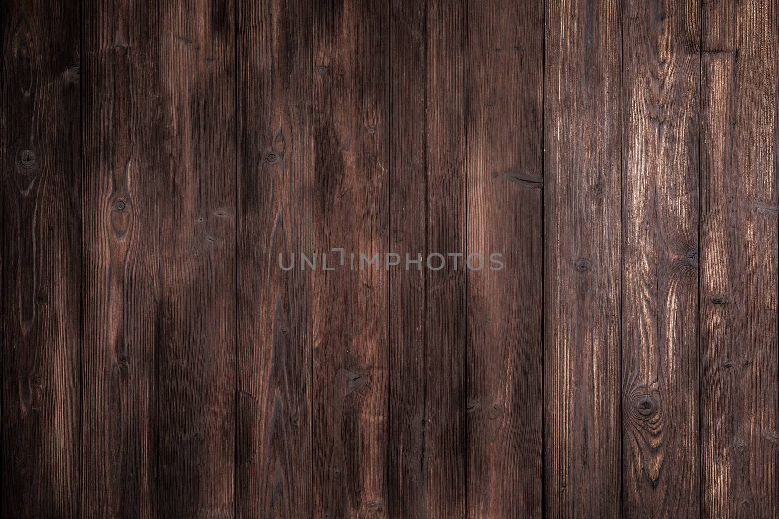 Dark brown wooden tiles floor texture background with dramatic light