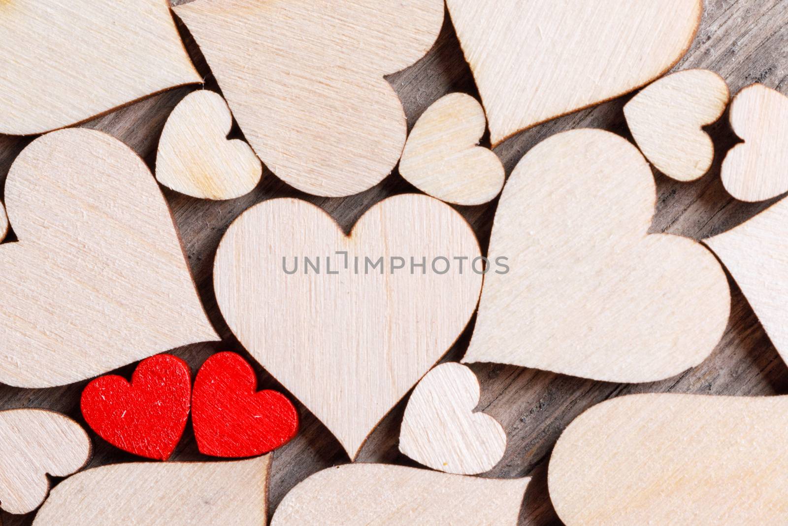 Many wooden colorless hearts background, two red special ones true love concept