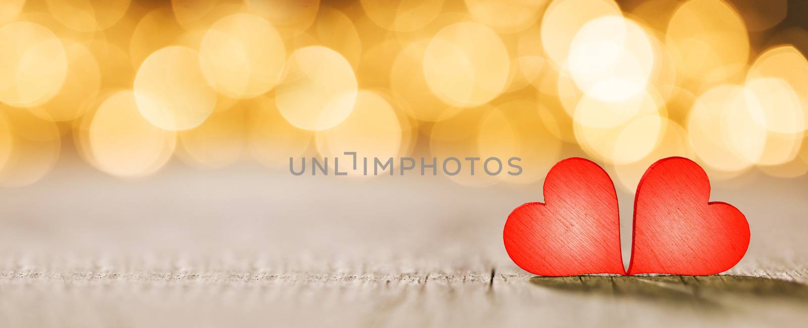 Two handmade red wooden hearts on beautiful golden bokeh background. Vintage style. Love Valentine's Day concept.