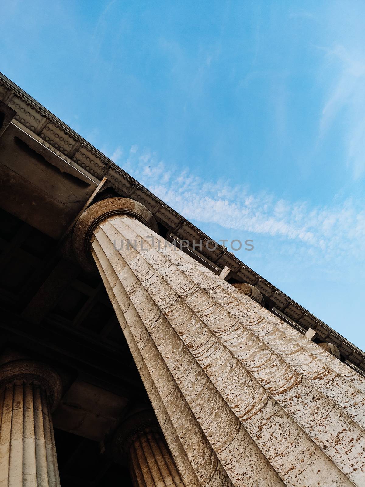 Columns on blue sky background. Vertical photo