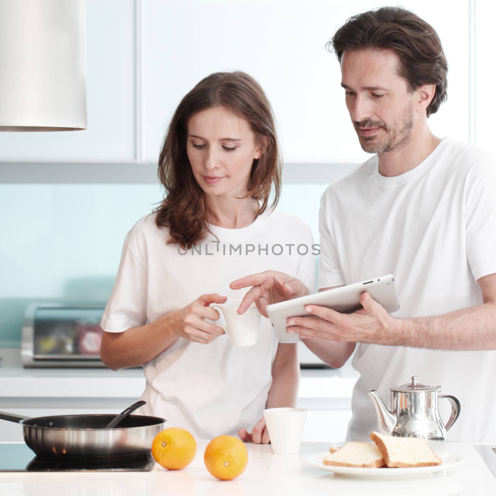 Happy couple cooking breakfast together in the kitchen