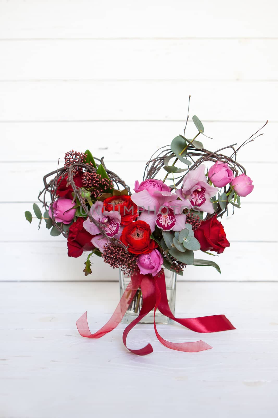 Unusual creative bouquet of flowers in shape of heart on white wooden background. February 14 card for Valentine's day. Flower delivery, wedding agencies. Mother's day, 8 March, Happy Women's Day.