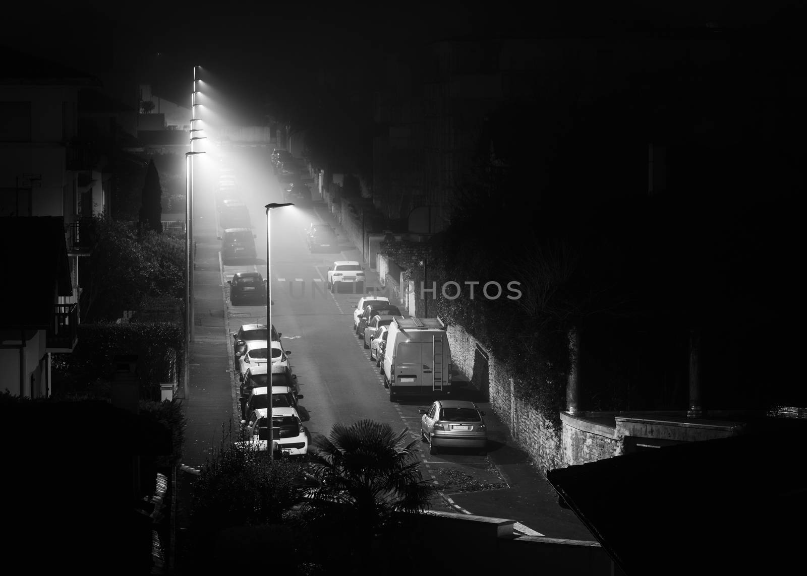 Empty street by a foggy night in Bayonne, France. Black and white photography.