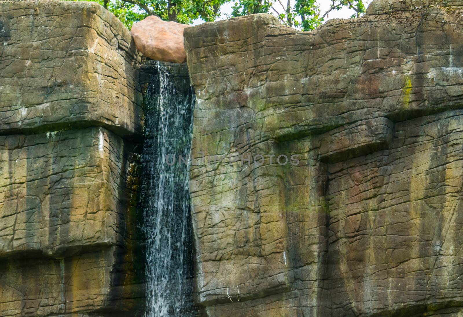 waterfall streaming of a rocky cliff, nature background, garden architecture by charlottebleijenberg