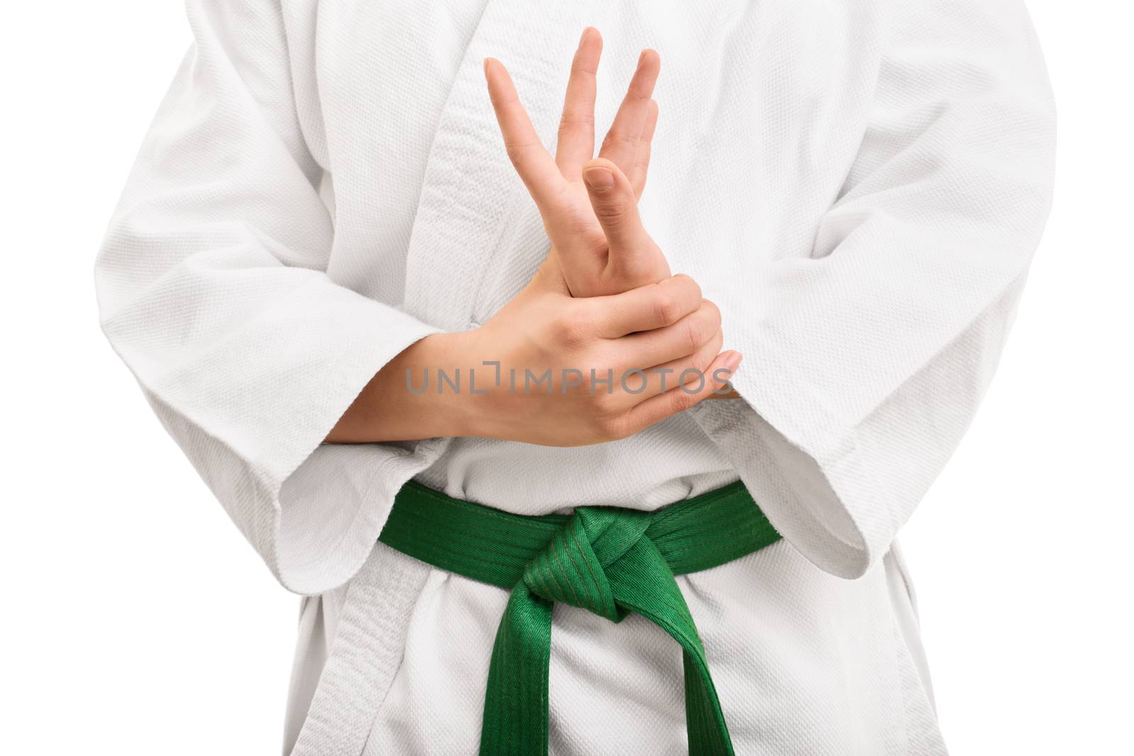 Mid section of a martial arts fighter in white kimono with green belt stretching and twisting her hand, isolated on white background.