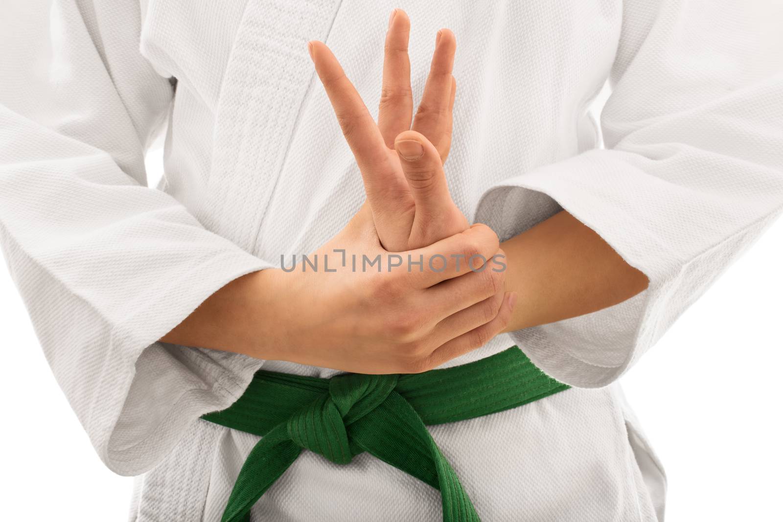 Close up shot of the mid section of a martial arts fighter in white kimono with green belt stretching and twisting her hand, isolated on white background.