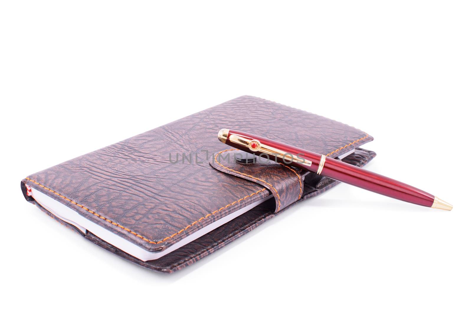 Close up shot of a leather planner notebook with a pen , isolated on white background.