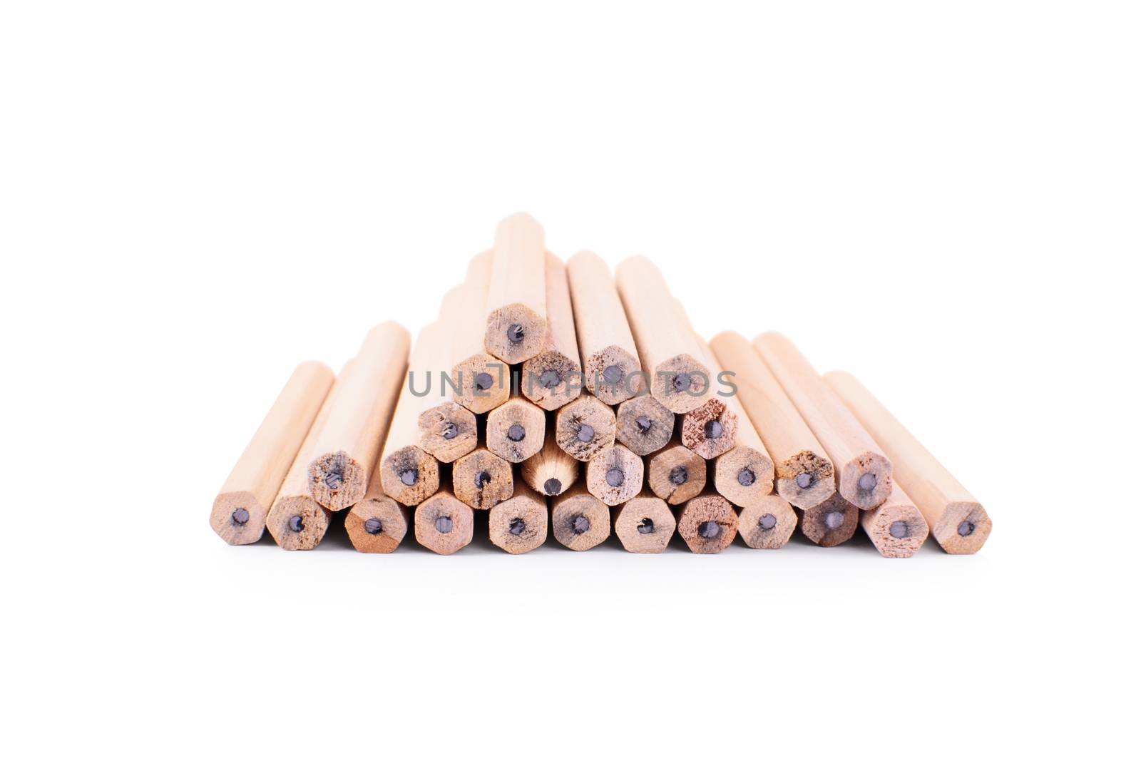 One makes a difference. Pencils stacked on top of each other in the form of a pyramid with one turned with the tip towards the camera, isolated on white background.