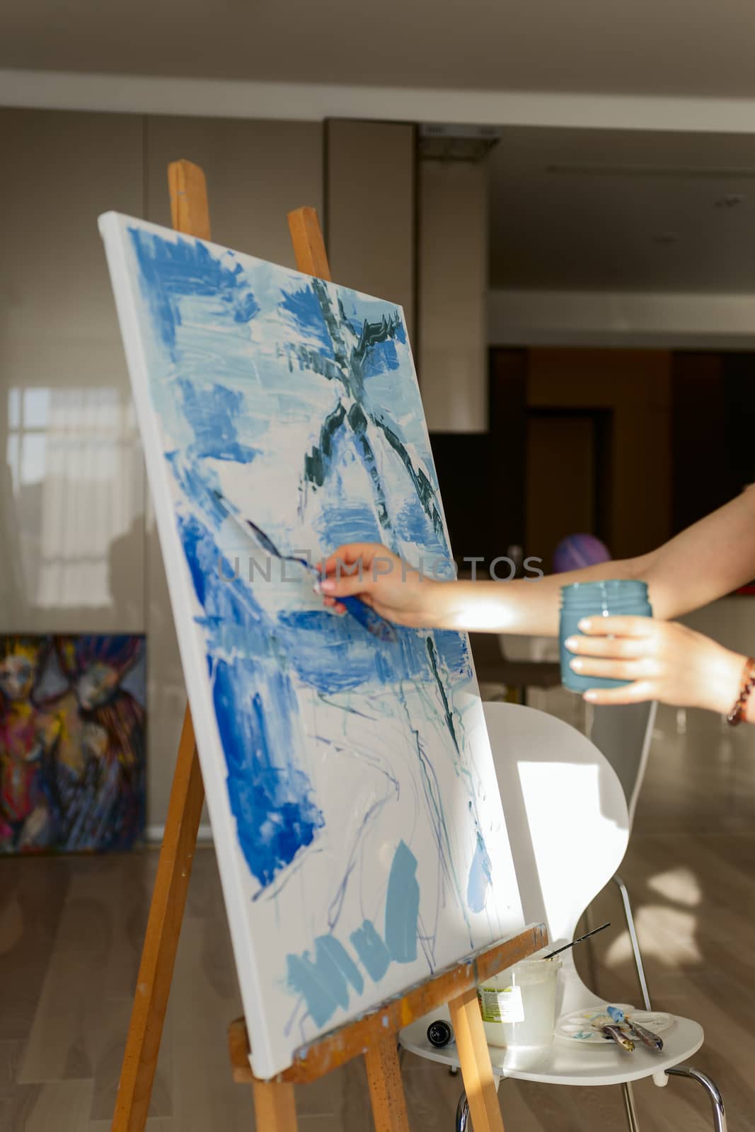 Woman paints a picture on canvas in her living room
