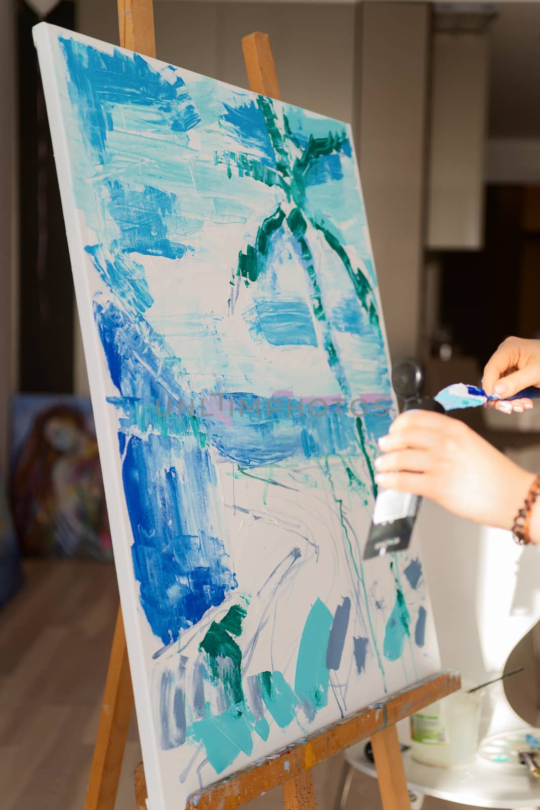 Woman paints a picture on canvas in her living room