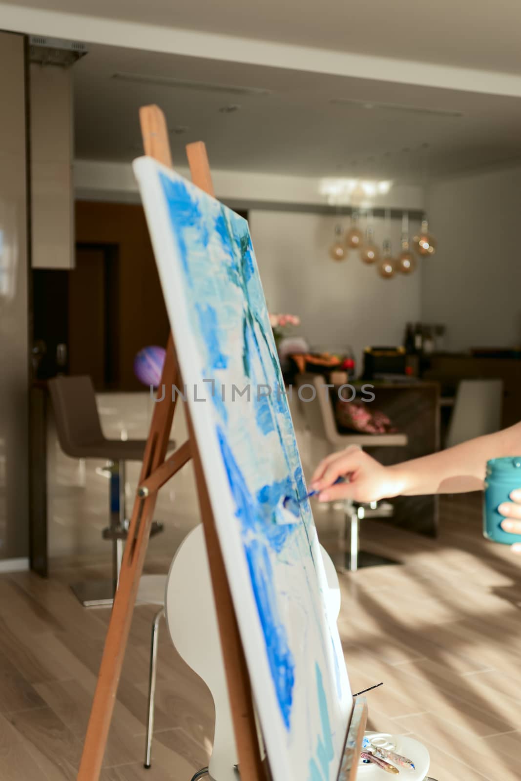 Woman paints a picture on canvas in her living room