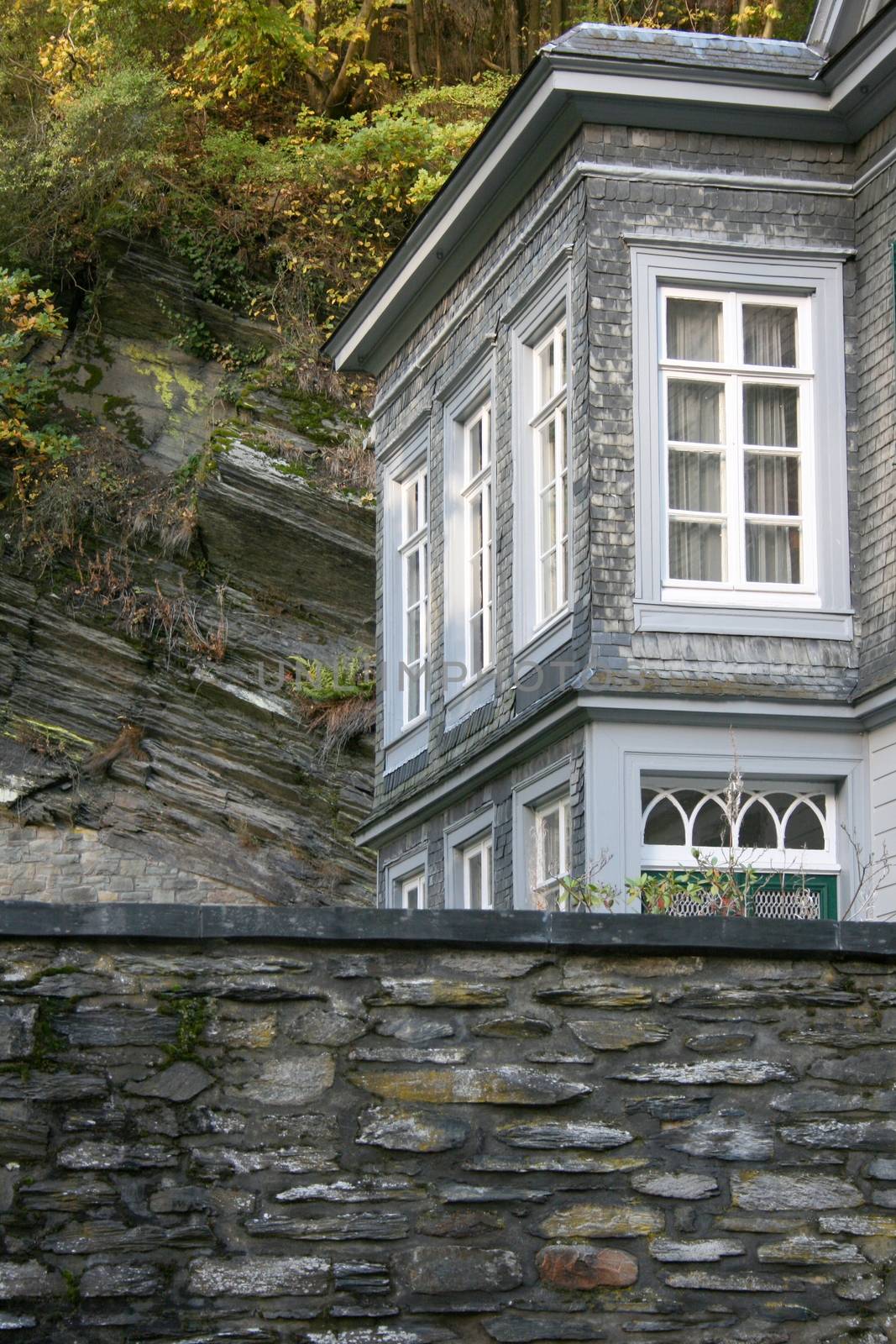 A high stone wall with house corner