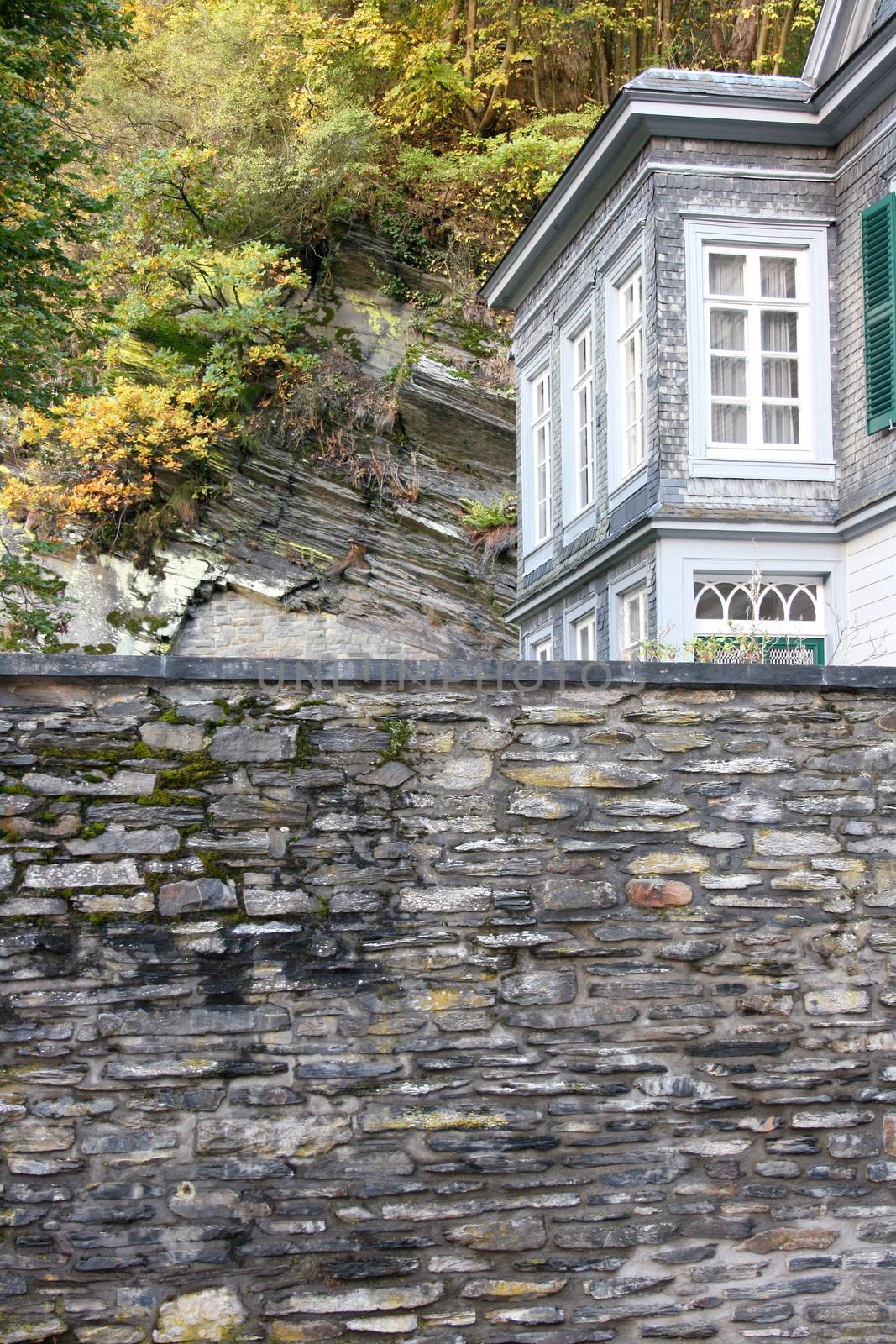 A high stone wall with house corner